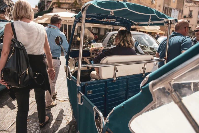 a group of people standing in front of a boat with a canopy on it