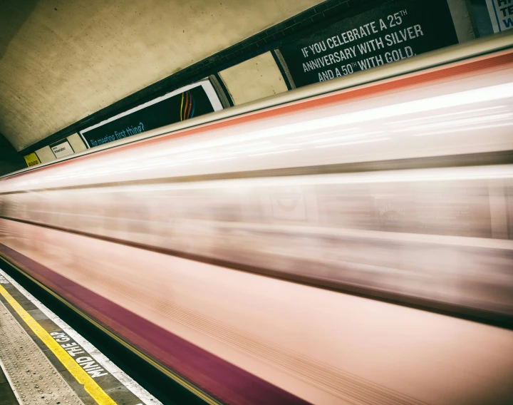 a speeding train is seen through the window of a passing vehicle