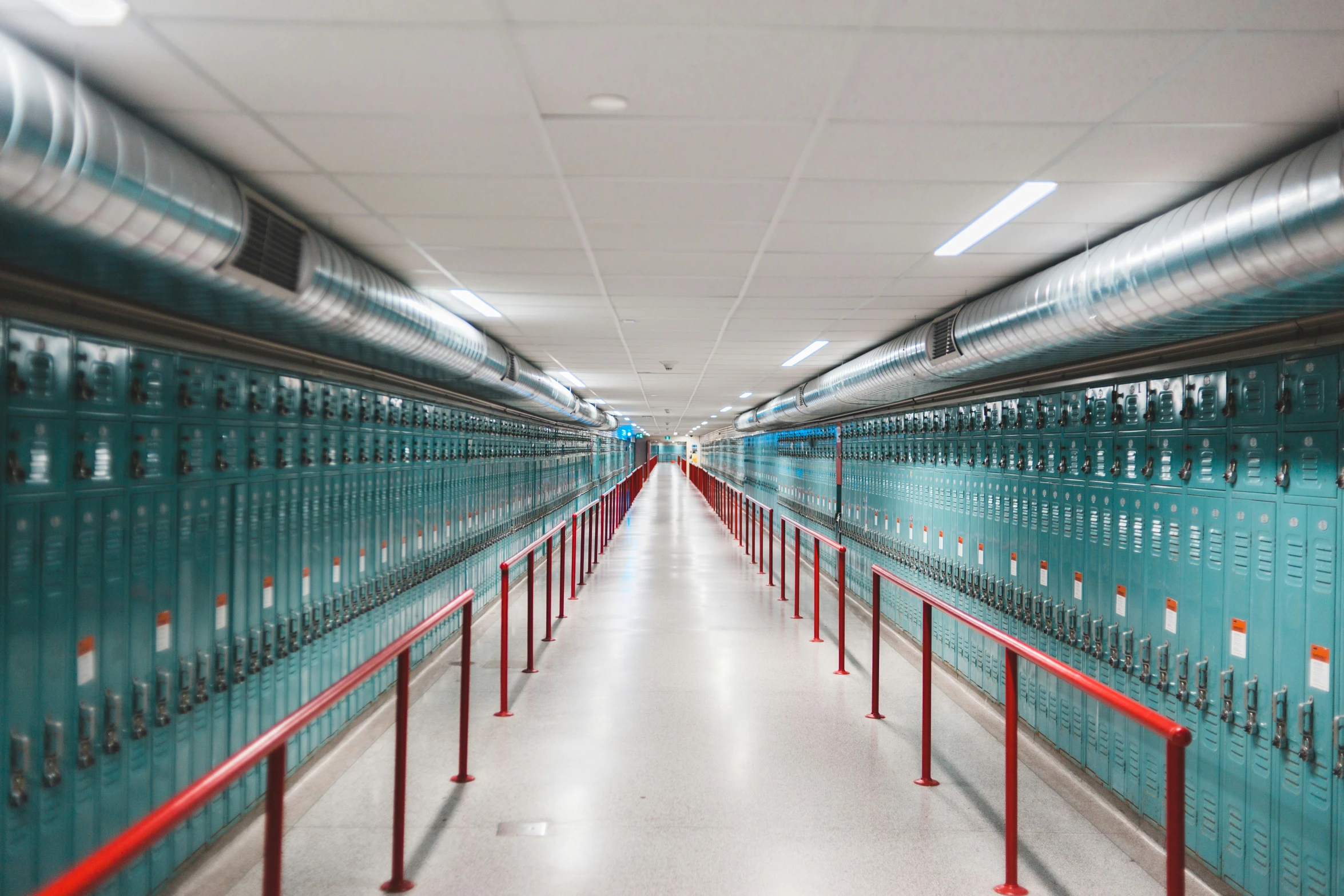 an aisle in a building lined with many rows of metal lockers