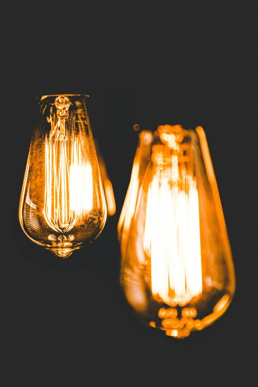 two orange colored bulbs are on a black table