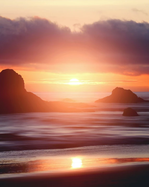 a beach with some water in the sunset