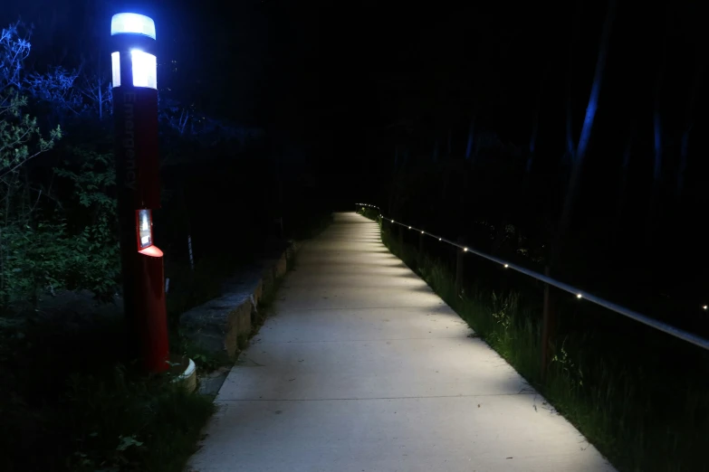 the lights on the street are bright and on the walkway