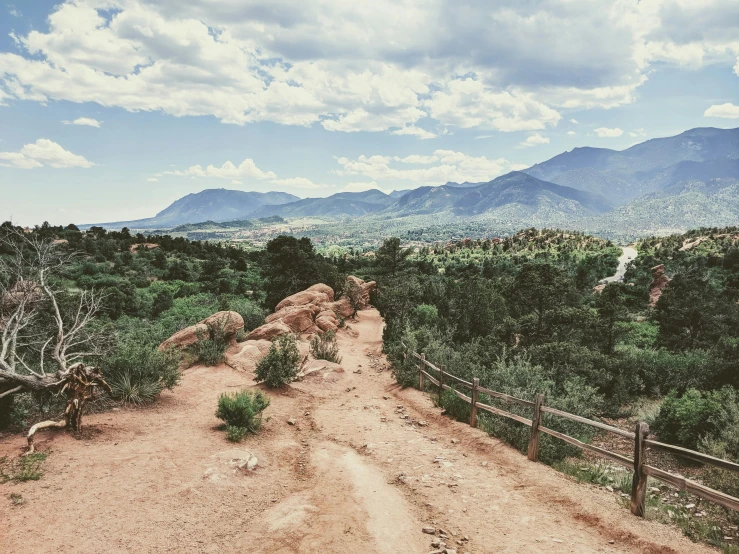 the dirt road is near the green hills