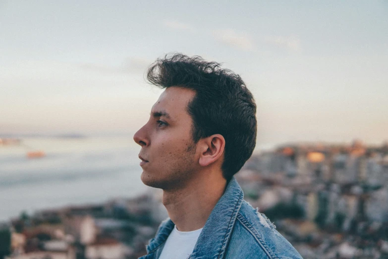 a man looking at the camera, with a city in the background