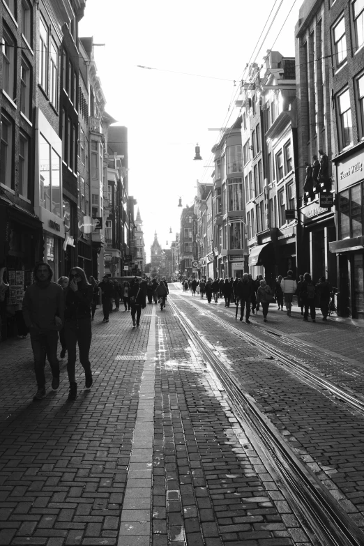 a city with people walking down the side walk and buildings