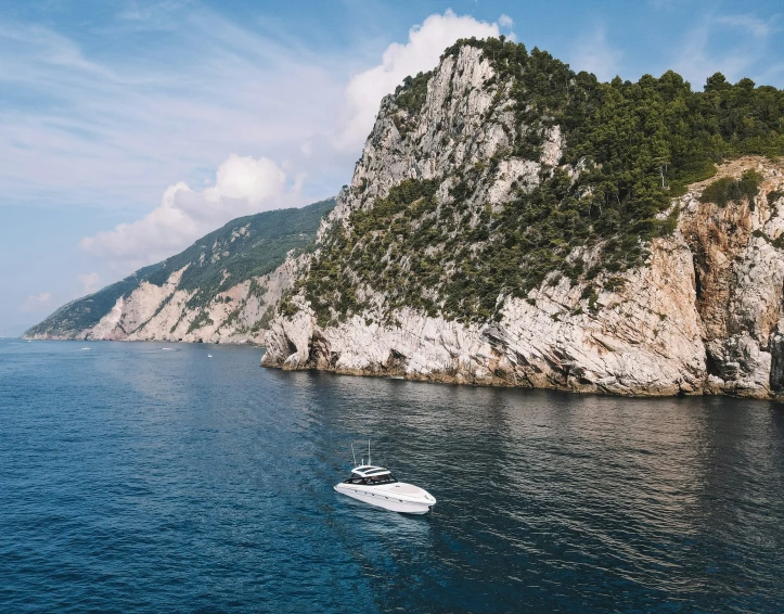 a boat is on the ocean near a mountain