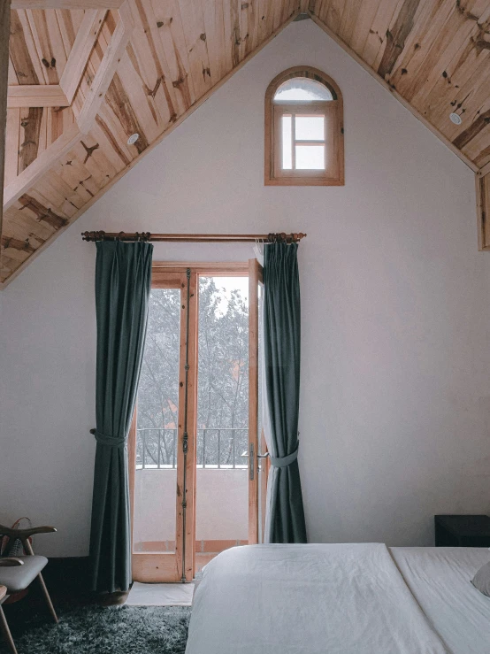 a large white bed in a bedroom next to a window