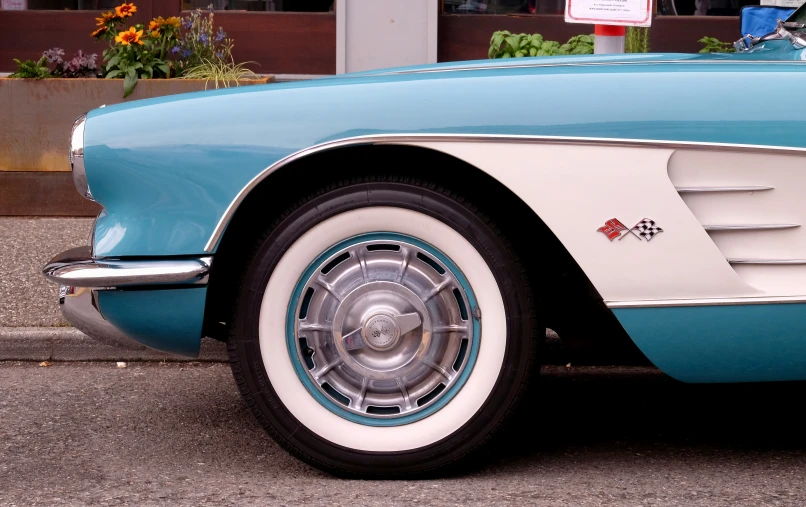 a blue and white car parked next to a parking meter