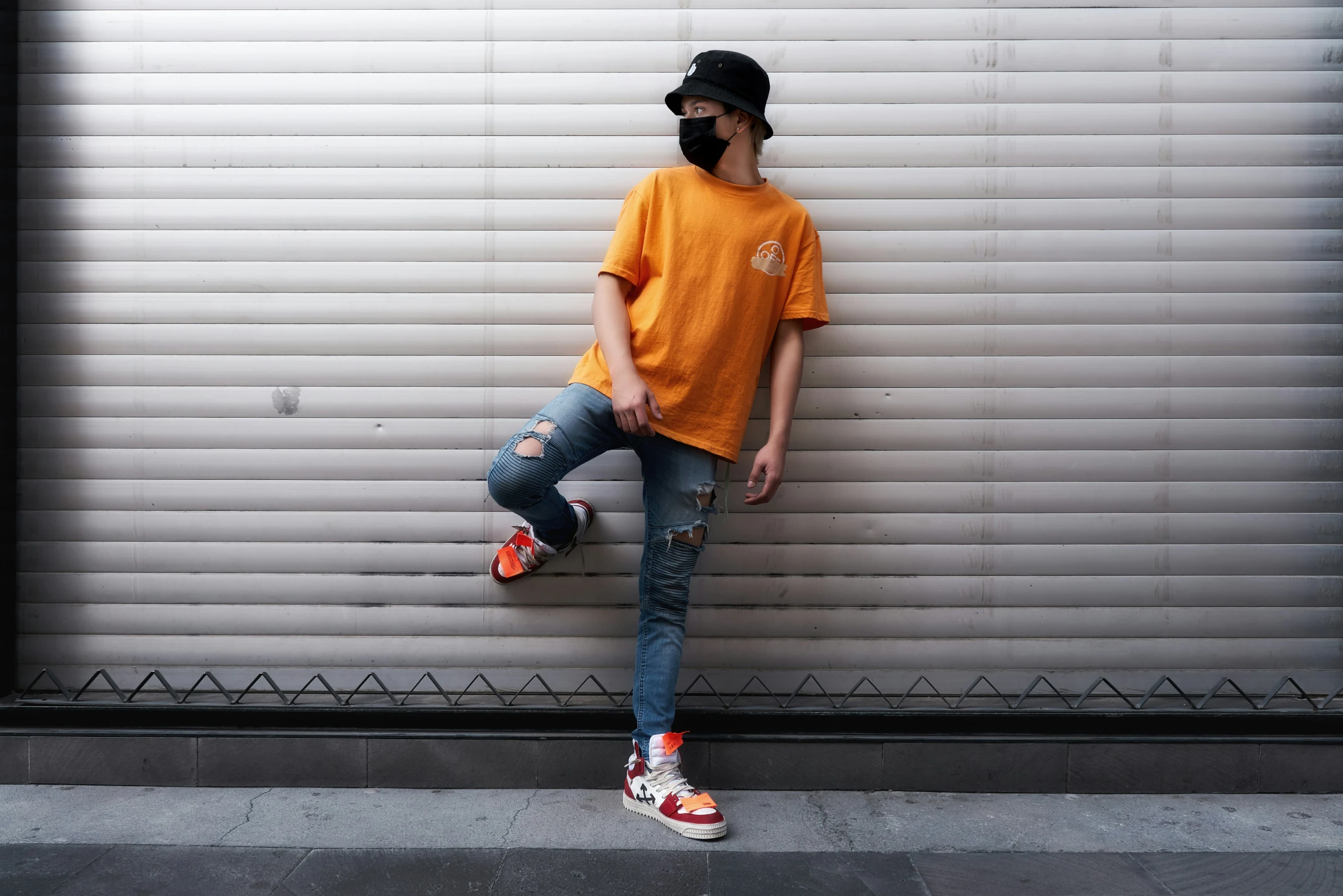 a boy posing wearing a mask in front of the roller door