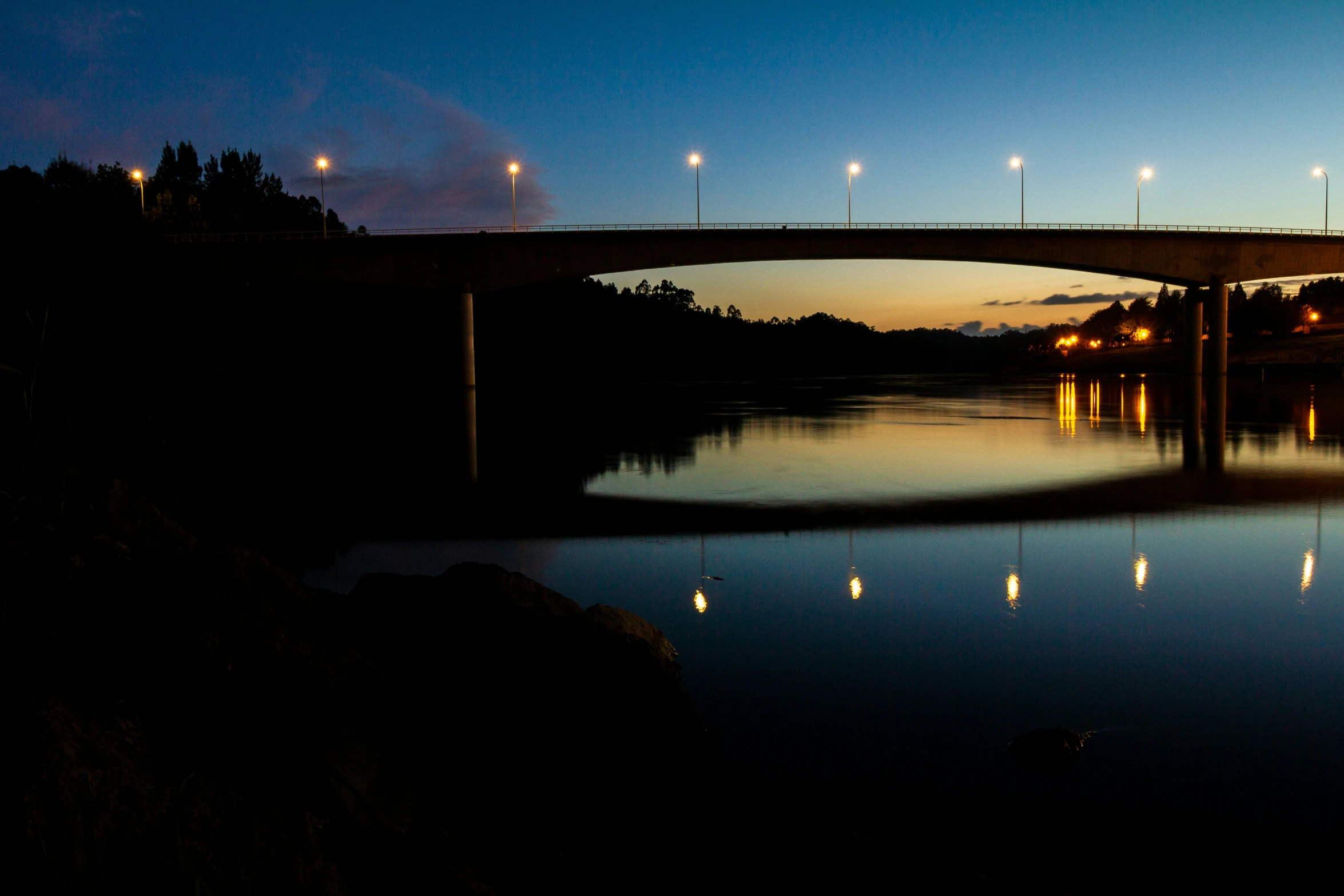 a bridge is lit up over the water