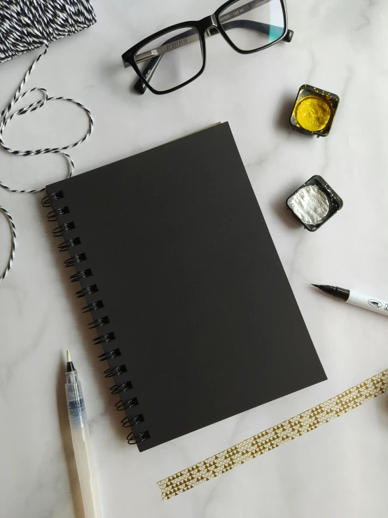 a note book and pen are laying on the desk