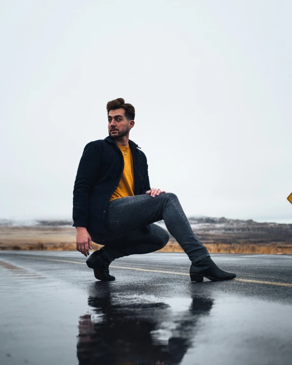 a man crouches down in the road