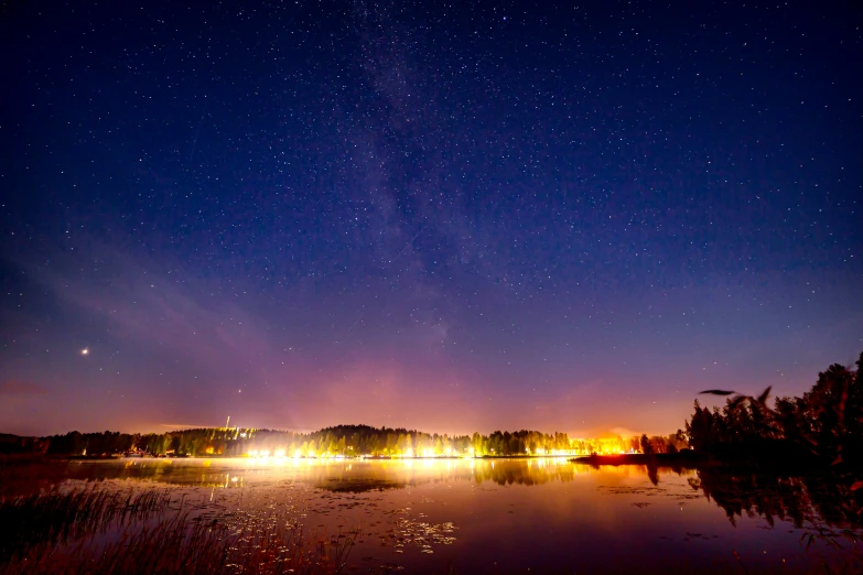 the sky is reflected in the water at night