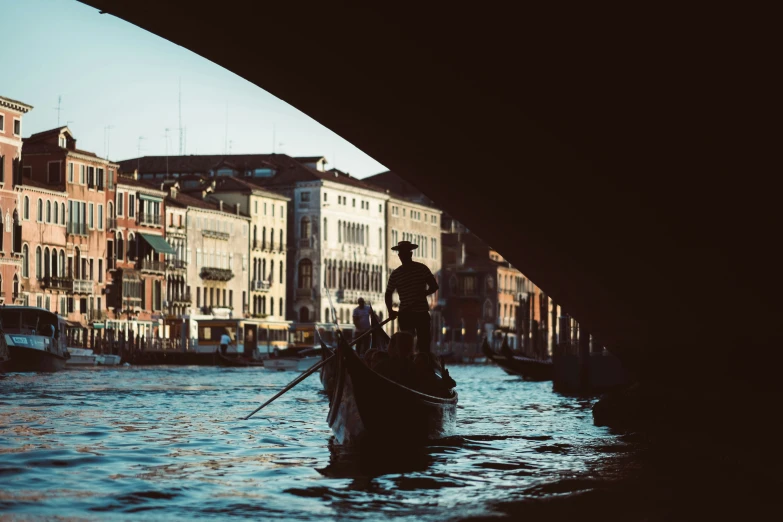 a boat with people is under a bridge