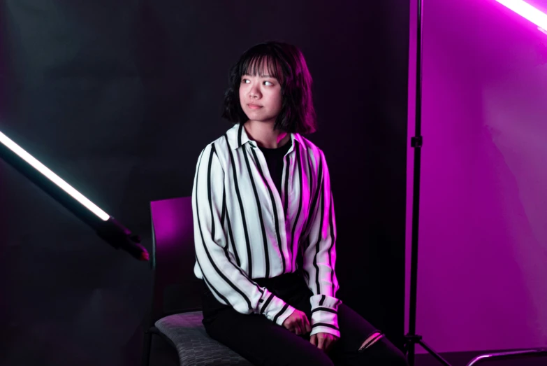 a young woman in a shirt sitting in a chair