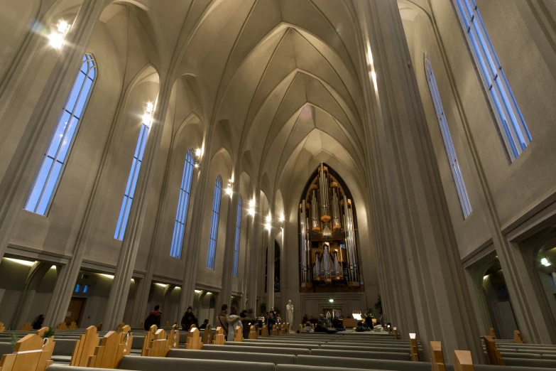 the interior of a large cathedral has pews and a beautiful stained window