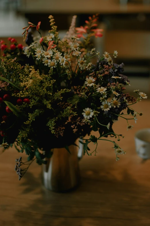 a bouquet of wildflowers in a metal vase