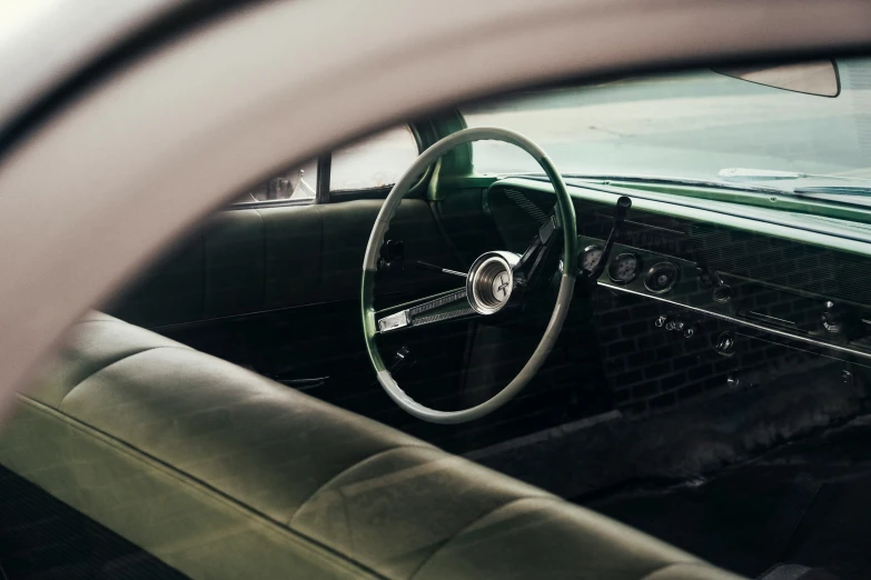 inside of a green car that is parked in a driveway