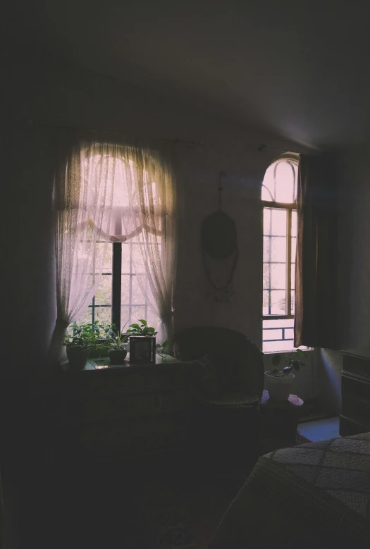 a window and an empty chair in a darkened room