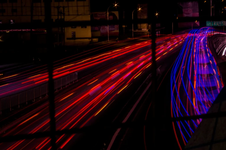 a bunch of cars are traveling in the street at night