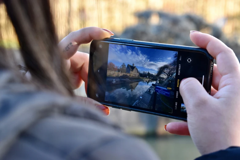 someone holding up a camera to take a picture of a reflection