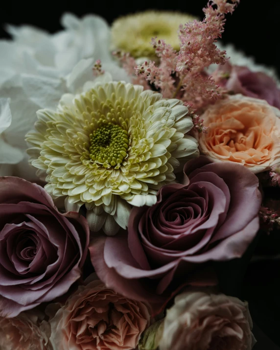 flowers are arranged in a vase with different colored blooms