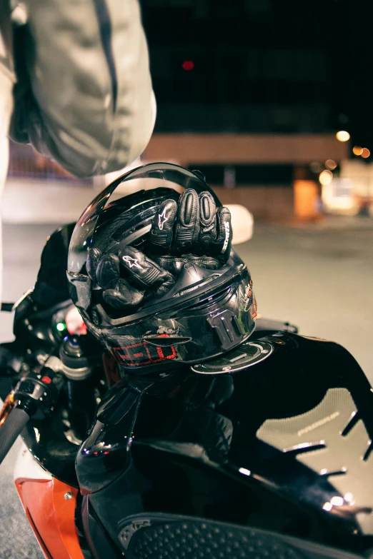 a person wearing an orange motorbike and holding their helmet