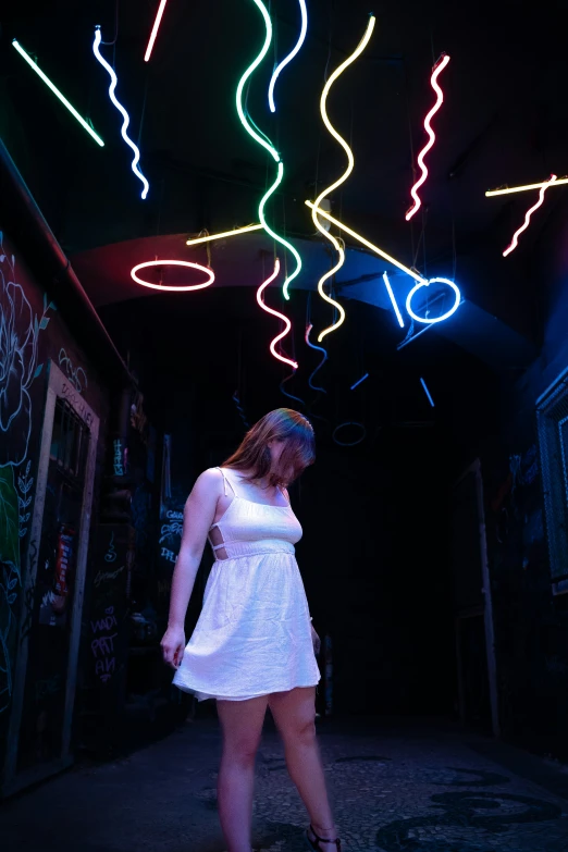 a woman standing in front of a large neon display