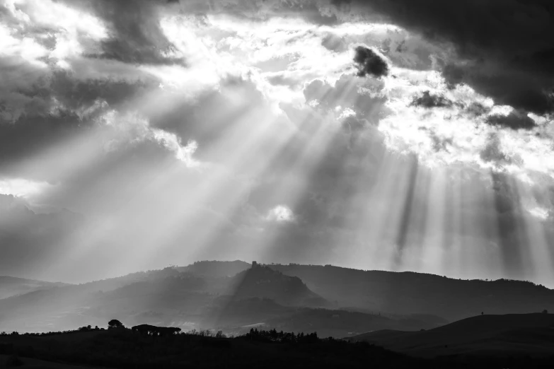 the sun is shining through clouds in the mountains