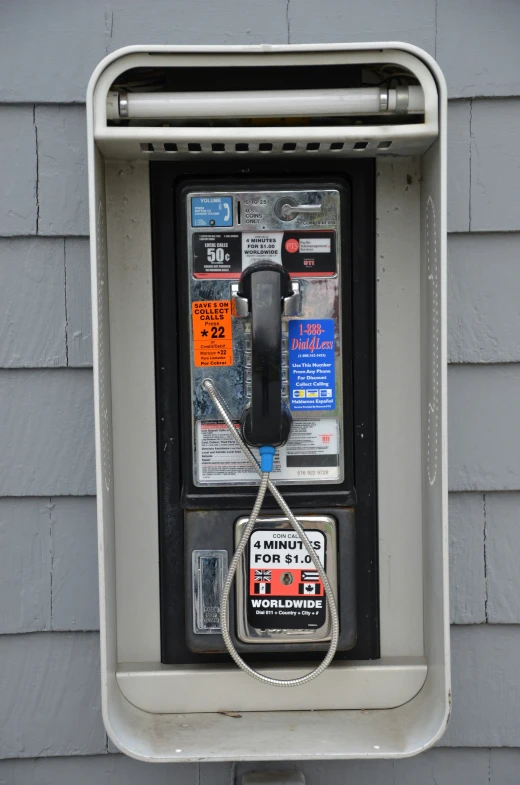 a public phone booth with multiple parking tickets pinned to it