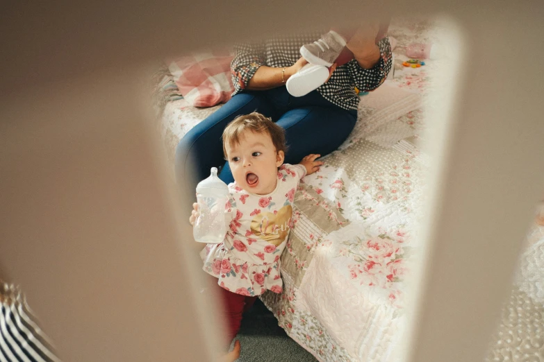 the child is on the bed and looking at the camera