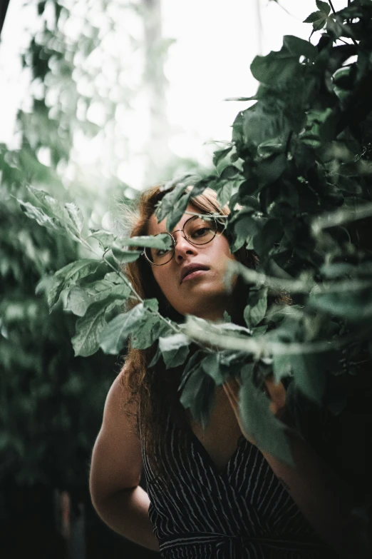 woman looking through the greenery to see the foliage