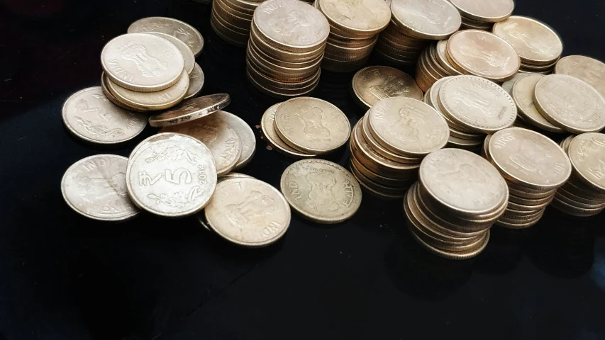 pile of twenty and twenty pound coins with the number ten one
