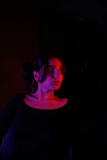 a woman with red light in a dark room