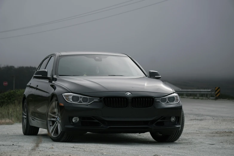 a black car sitting on the side of a road