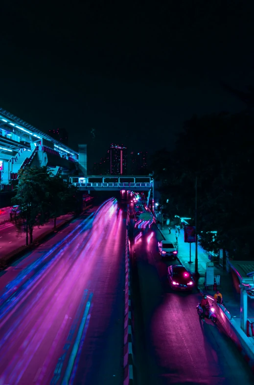 a city at night has pink lights all over the street