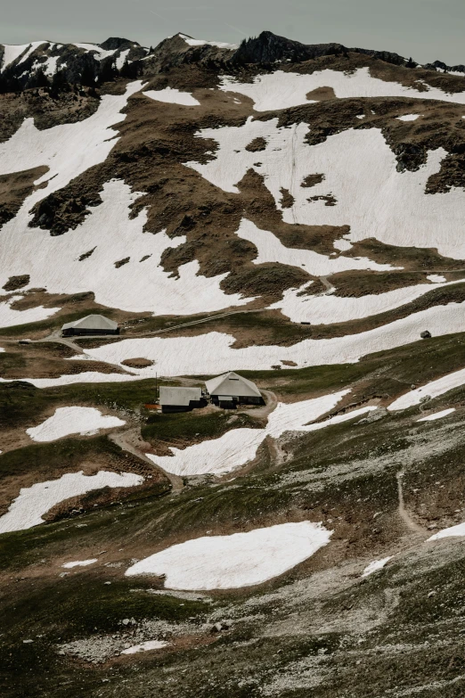 some snow mountains with some buildings and trees