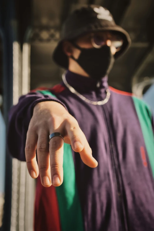 a man wearing a mask on the street and pointing a finger