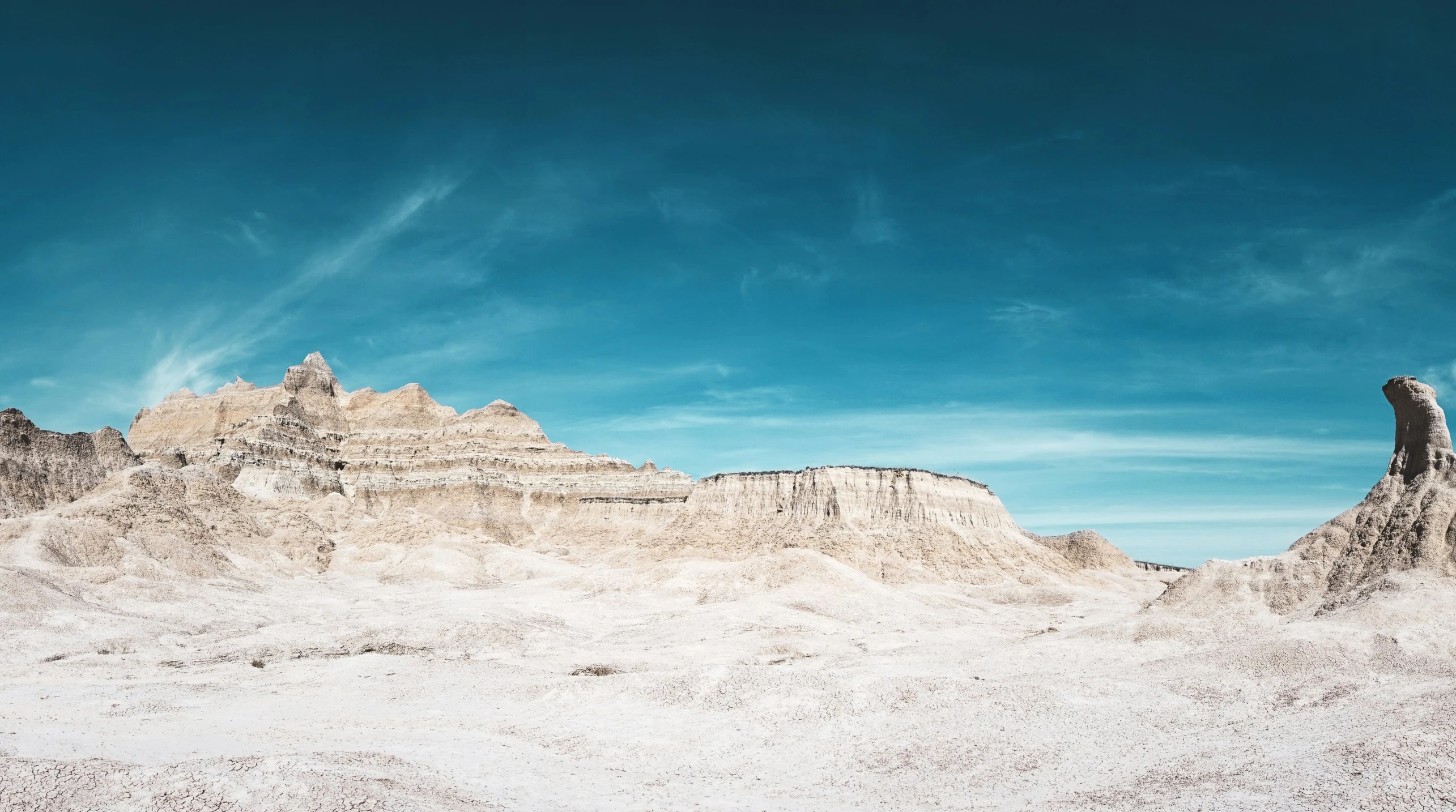 a mountain range covered in sp sand under a blue sky