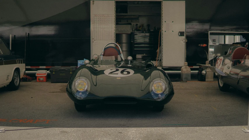 a vintage race car parked in front of a shop