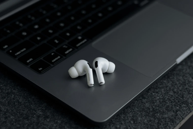 a laptop on a table with ear phones placed beside it