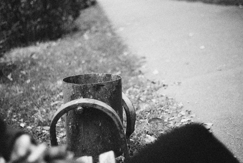 a barrel is sitting on the ground beside a street