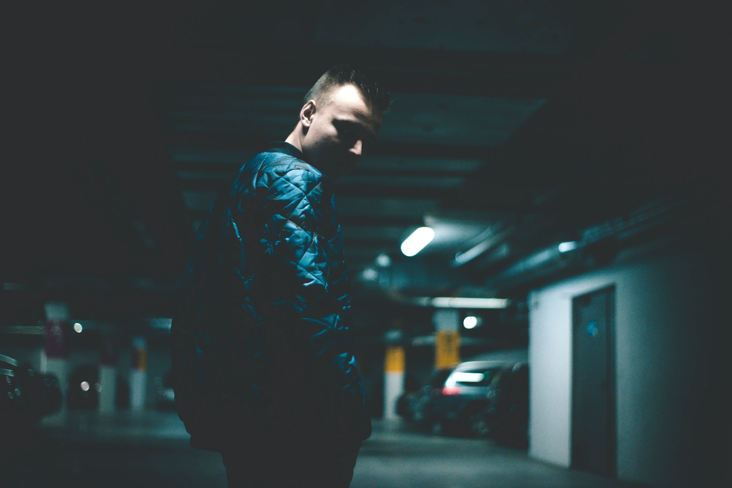 a man in a parking garage at night with the lights on