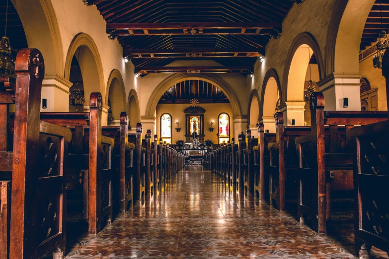 large long cathedral has wooden pews in it