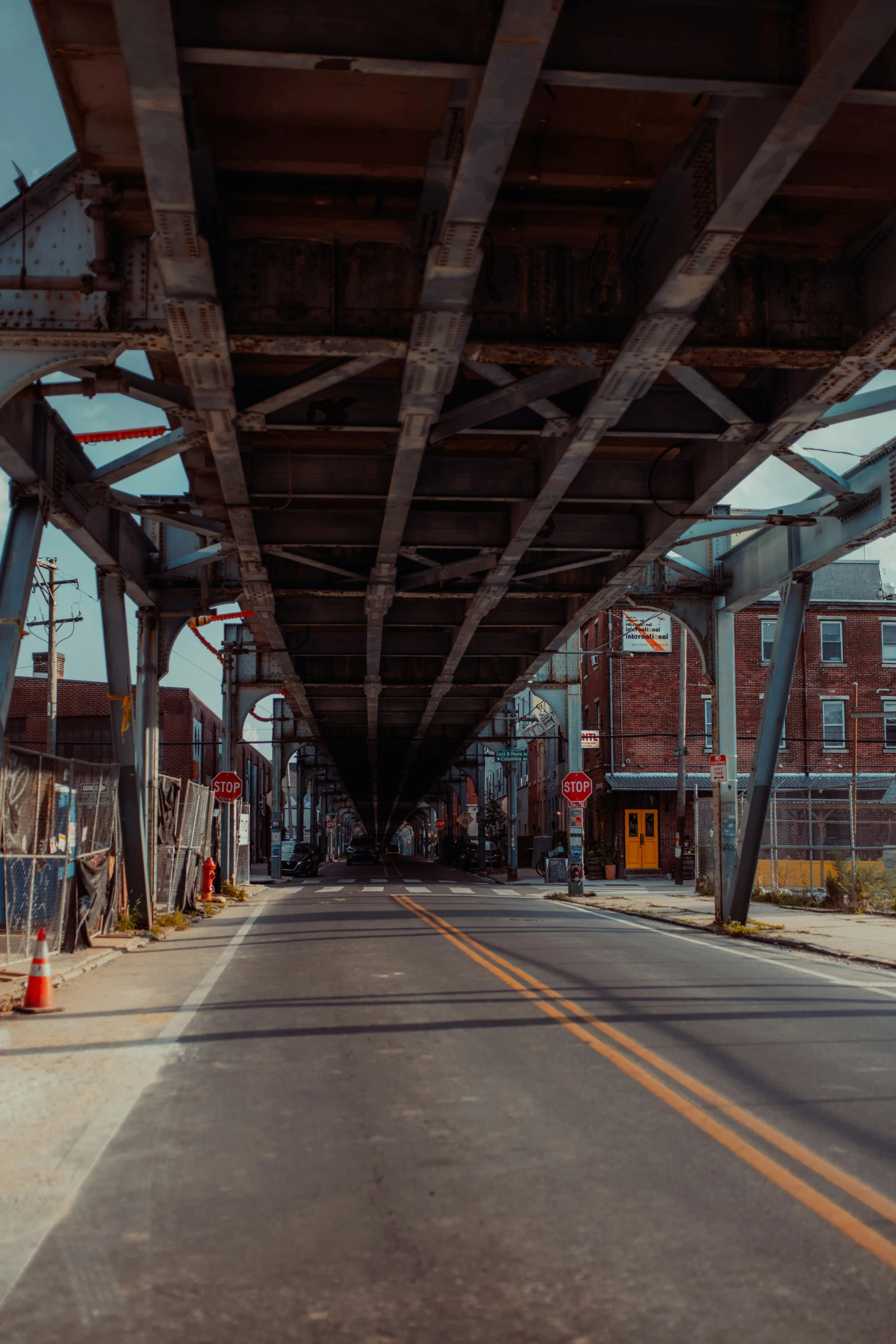 a long road going under an overpass next to a tall building