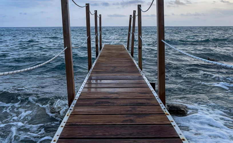 a dock extends into the water at an empty beach