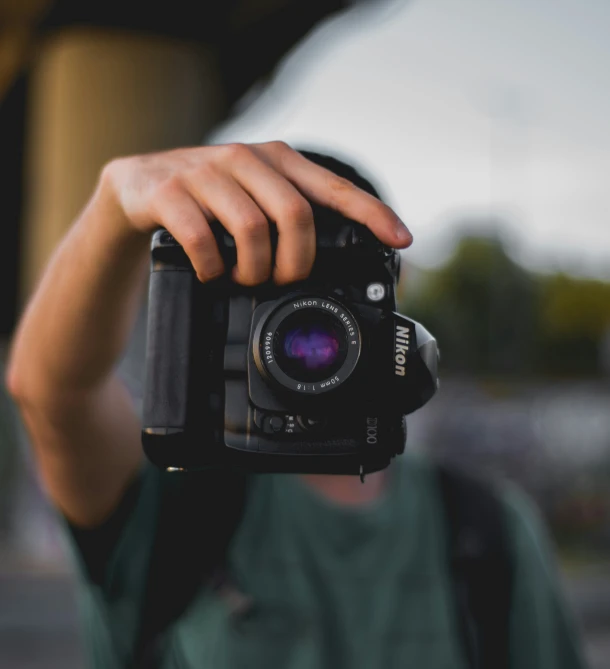 a man holds a camera up to take a po