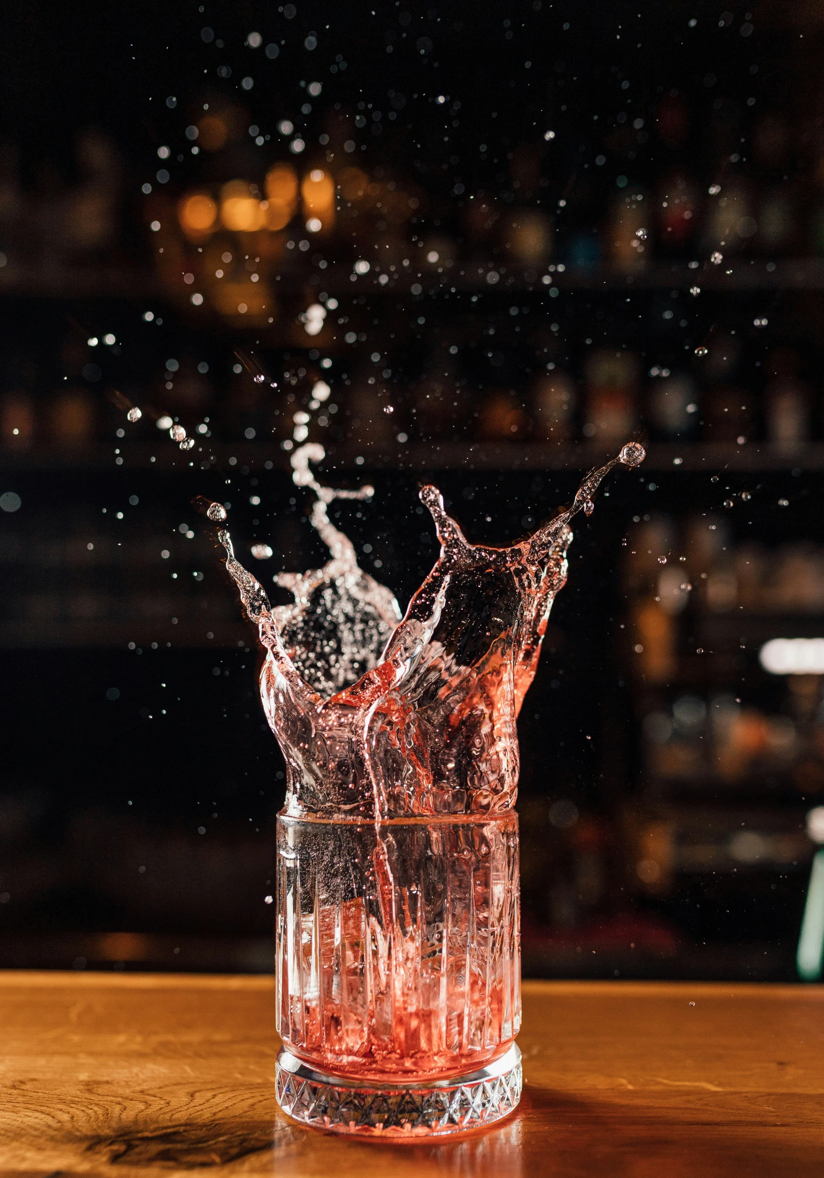 a glass of water being splashed with some liquid