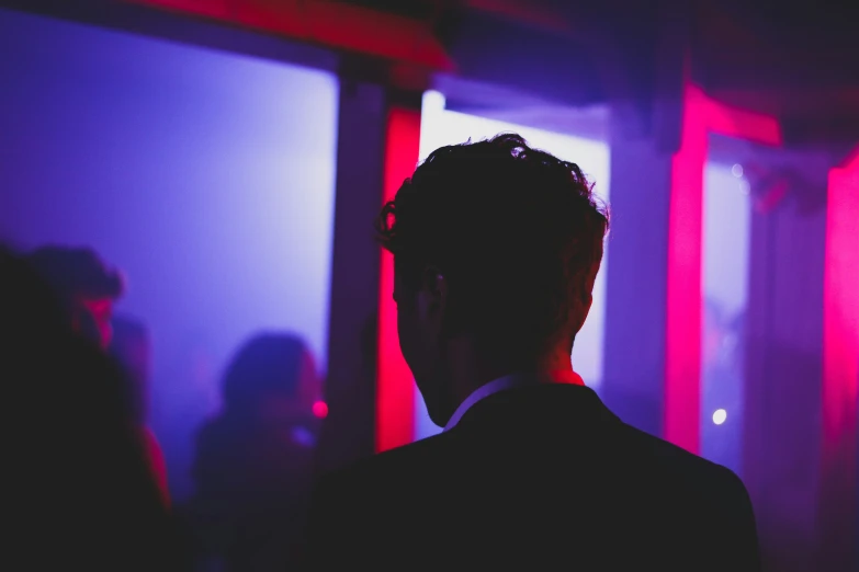 the back view of a man wearing a suit and tie