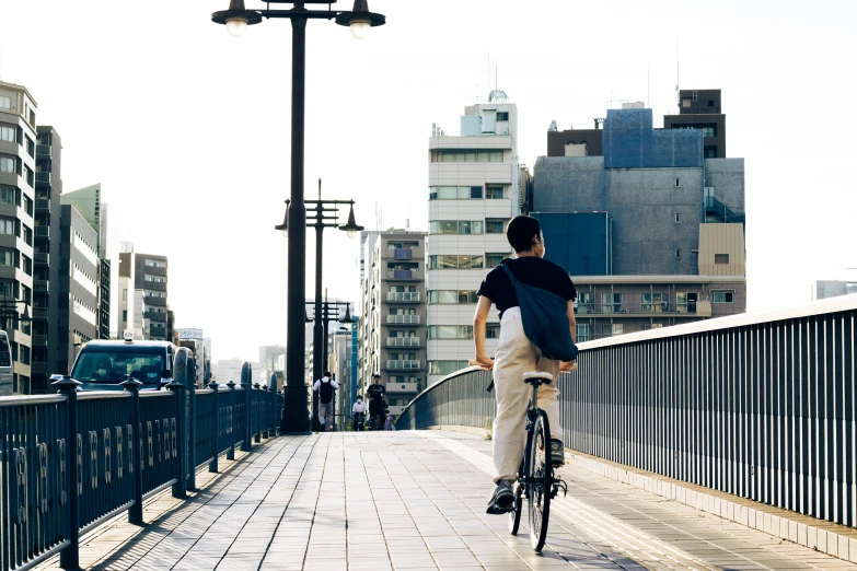 a man riding his bicycle over a bridge